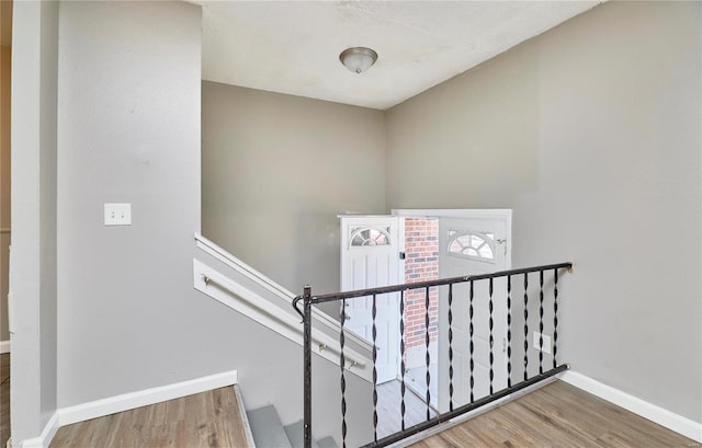 staircase with baseboards and wood finished floors