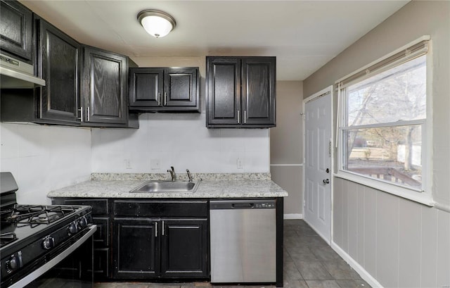 kitchen featuring a sink, dark cabinetry, black range with gas stovetop, tile patterned floors, and dishwasher