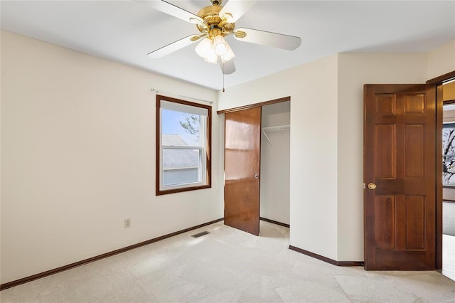 unfurnished bedroom featuring light carpet, baseboards, visible vents, ceiling fan, and a closet