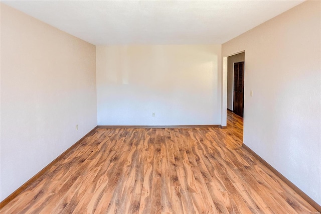 empty room with baseboards and wood finished floors