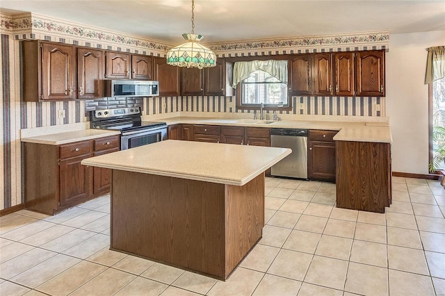 kitchen featuring appliances with stainless steel finishes, light countertops, a sink, and light tile patterned flooring