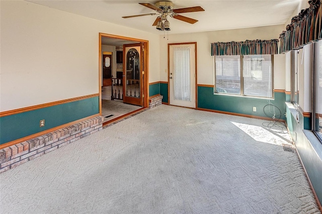 carpeted spare room with ceiling fan, visible vents, and baseboards