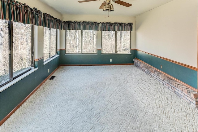 unfurnished sunroom with visible vents and a ceiling fan