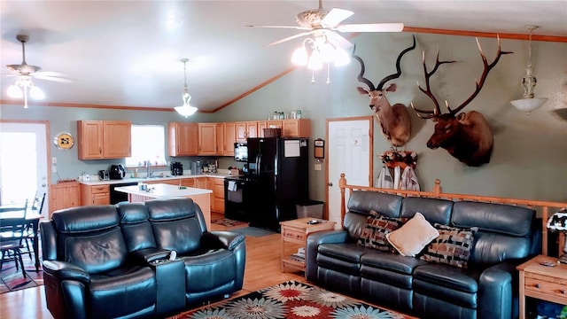 living room with lofted ceiling, light wood-style flooring, a ceiling fan, and crown molding