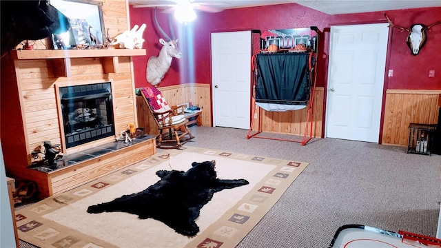 living room featuring a fireplace, wood walls, and wainscoting