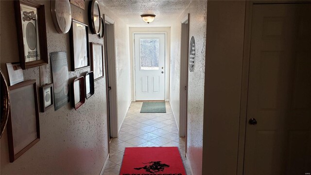 corridor with light tile patterned floors and a textured ceiling