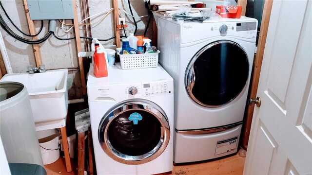 washroom featuring laundry area, independent washer and dryer, and a sink