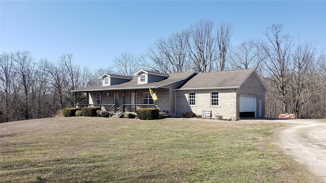 view of front facade with driveway, a front lawn, a porch, an attached garage, and brick siding