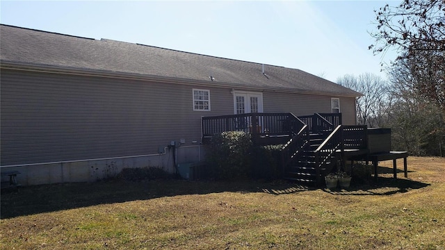 back of house featuring a yard, roof with shingles, a deck, and stairway