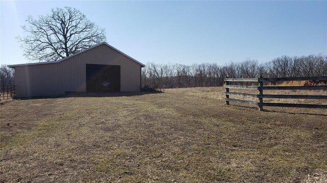 view of yard with an outbuilding, a pole building, and fence