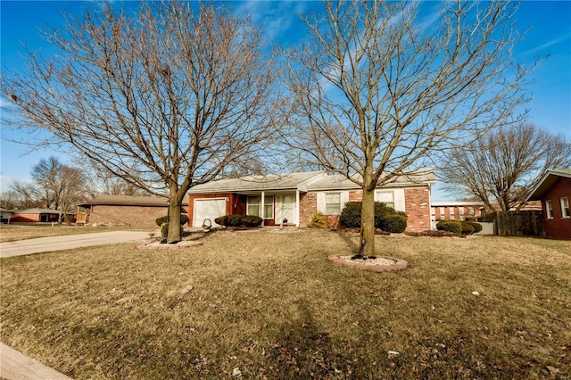 ranch-style house featuring driveway, a garage, fence, a front yard, and brick siding