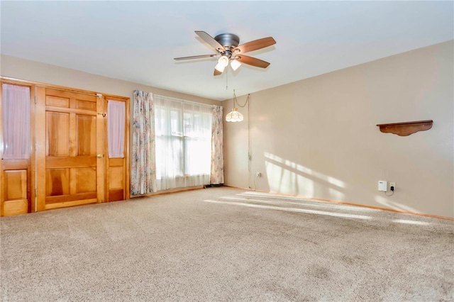 carpeted empty room featuring a ceiling fan