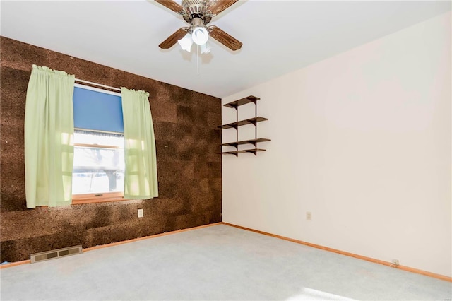 unfurnished room featuring baseboards, visible vents, ceiling fan, and carpet flooring