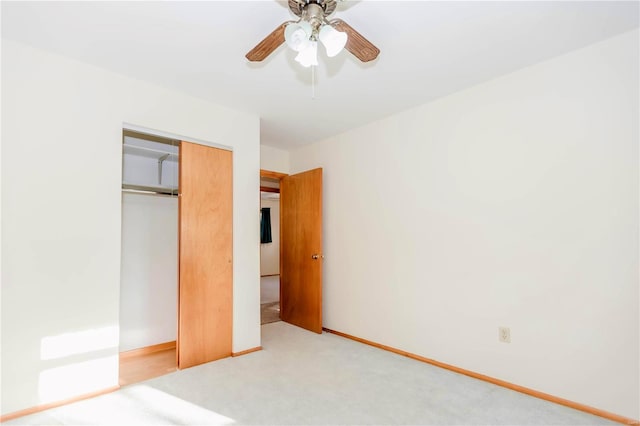 unfurnished bedroom with ceiling fan, a closet, carpet, and baseboards