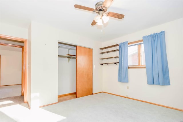 unfurnished bedroom with a closet, carpet, a ceiling fan, and baseboards