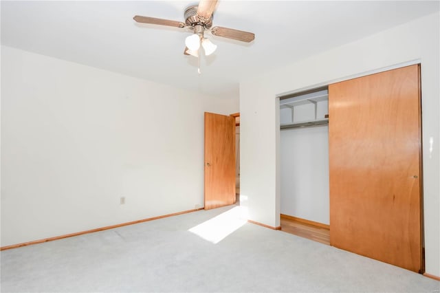 unfurnished bedroom featuring carpet, a closet, ceiling fan, and baseboards