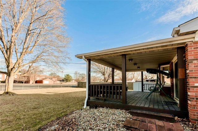 wooden deck featuring a lawn and fence