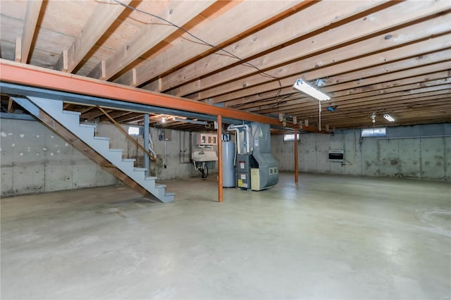 below grade area featuring stairs, gas water heater, a sink, and heating unit