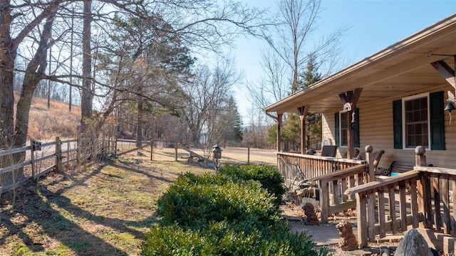 view of yard featuring a porch and fence