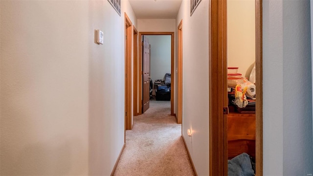 hallway with light carpet and visible vents