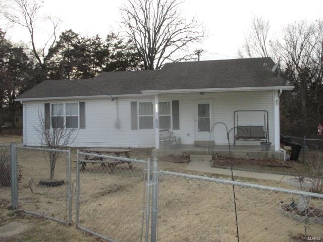 ranch-style home with a fenced front yard, covered porch, and a gate