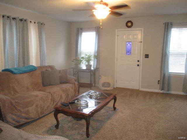 carpeted living area featuring ceiling fan and baseboards