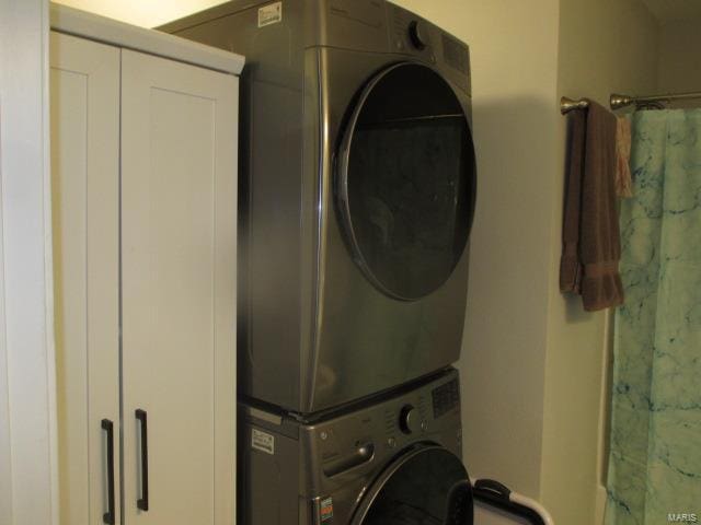 clothes washing area with laundry area and stacked washing maching and dryer