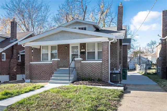 bungalow with driveway, a chimney, a porch, and brick siding