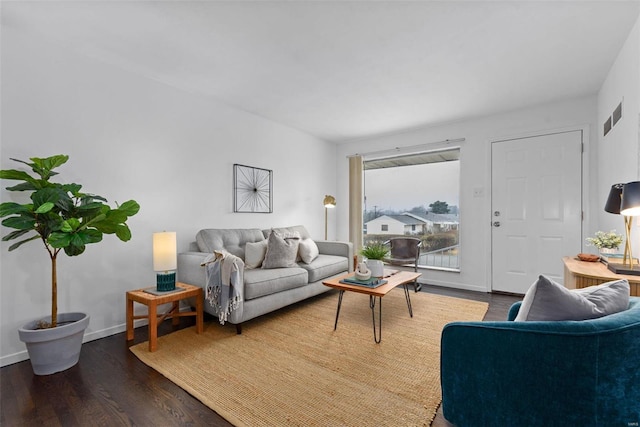 living room with baseboards, visible vents, and dark wood-type flooring