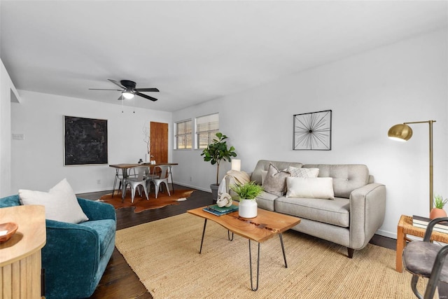 living area with baseboards, a ceiling fan, and wood finished floors