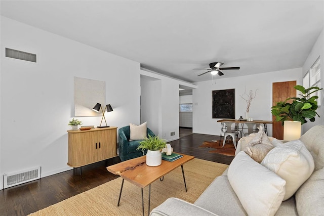 living room featuring a ceiling fan, visible vents, and wood finished floors