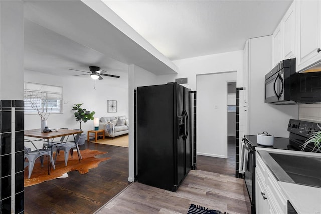 kitchen featuring a ceiling fan, baseboards, white cabinets, black appliances, and light wood finished floors