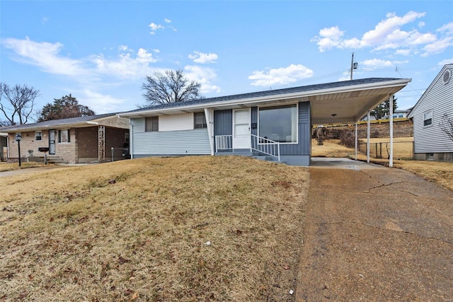 single story home with concrete driveway, an attached carport, and a front lawn