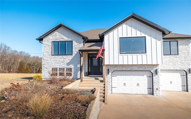 view of front facade with board and batten siding, stone siding, an attached garage, and concrete driveway