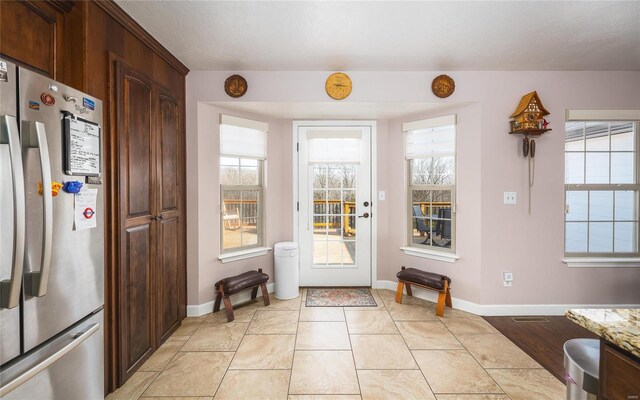 doorway to outside featuring baseboards