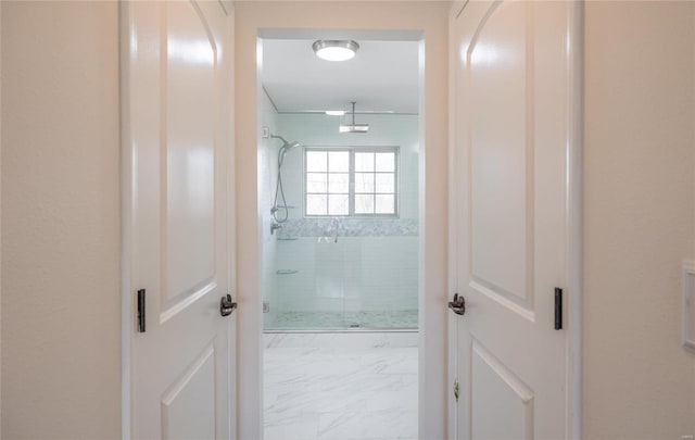 bathroom with marble finish floor and a shower stall