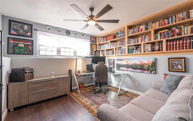 office area featuring baseboards, a textured ceiling, a ceiling fan, and dark wood-type flooring