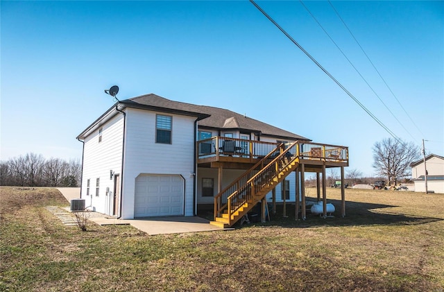 rear view of house with driveway, an attached garage, stairs, cooling unit, and a yard