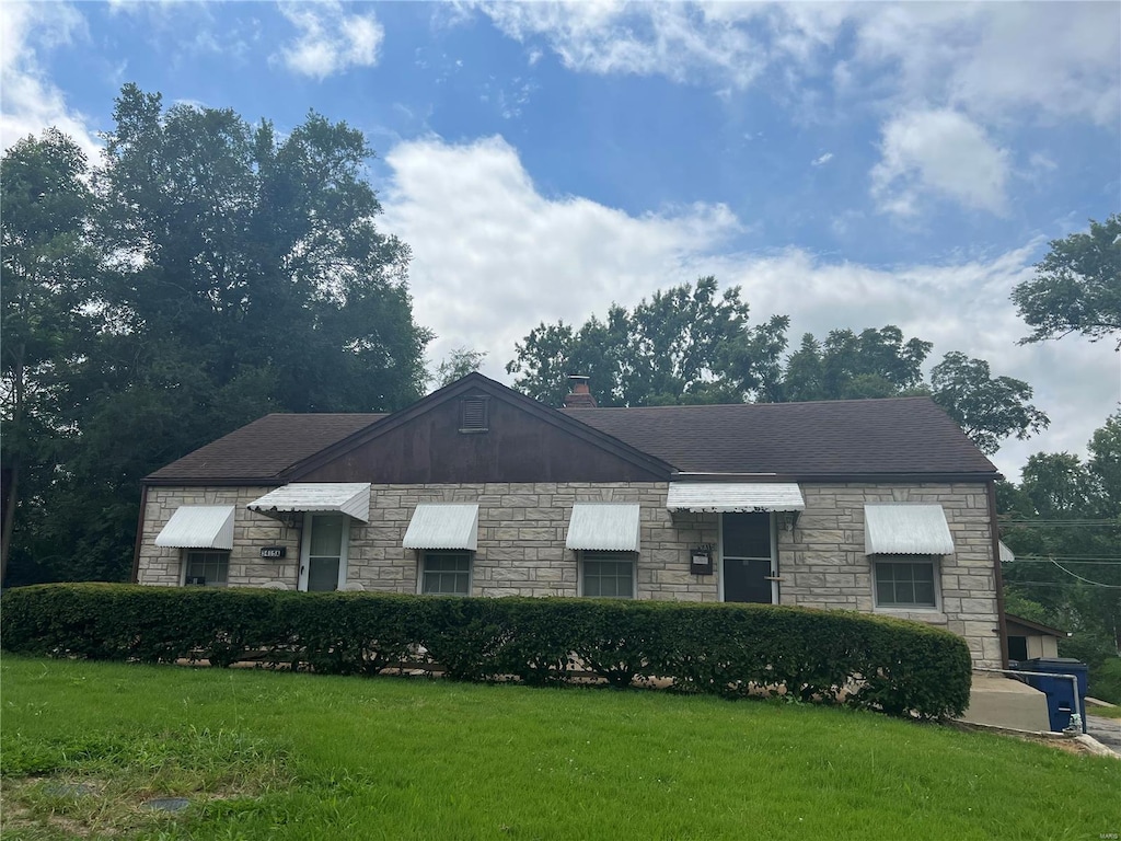 view of front of home featuring a chimney, a front lawn, and roof with shingles