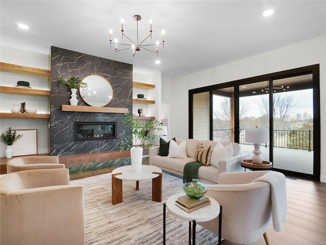 living room featuring built in features, recessed lighting, wood finished floors, and a premium fireplace