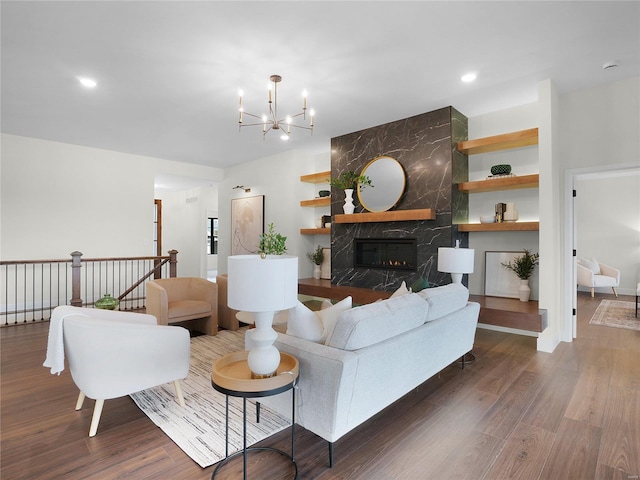 living room featuring an inviting chandelier, a premium fireplace, wood finished floors, and recessed lighting