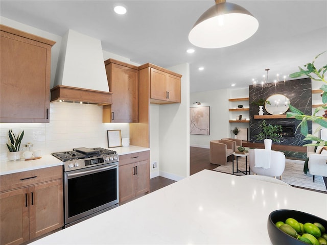 kitchen featuring decorative backsplash, dark wood-style floors, wall chimney exhaust hood, light countertops, and gas stove