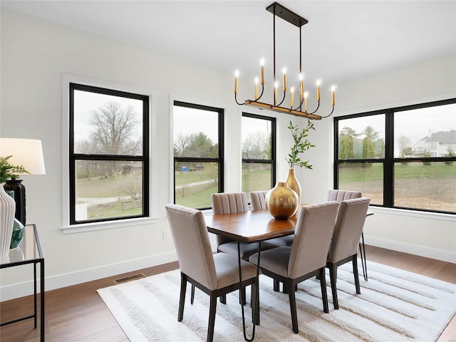 dining area with visible vents, baseboards, and wood finished floors