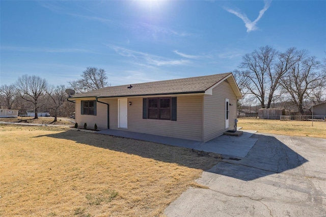 ranch-style home with fence and a front lawn