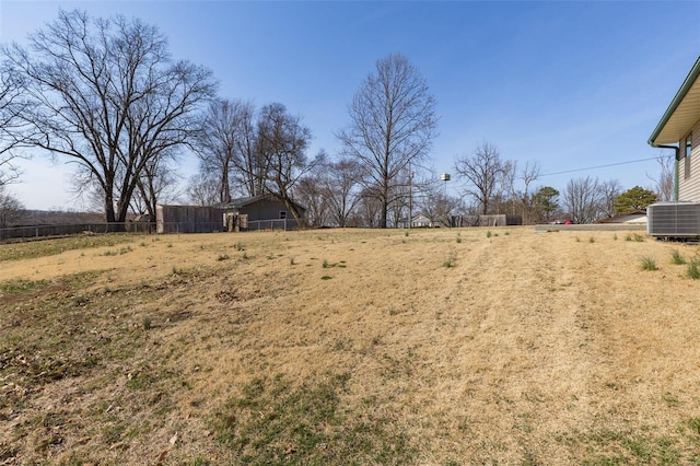 view of yard featuring central AC unit and fence