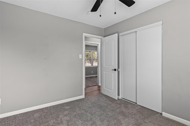 unfurnished bedroom with ceiling fan, a closet, carpet flooring, and baseboards