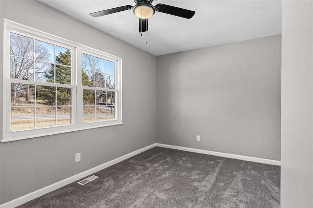 unfurnished room featuring visible vents, dark carpet, and baseboards