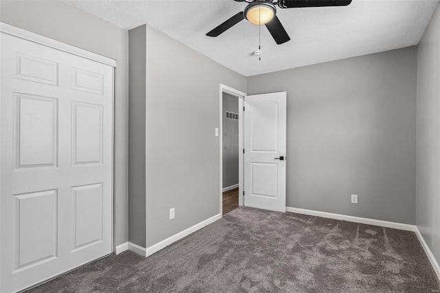 unfurnished bedroom featuring a textured ceiling, carpet floors, a ceiling fan, and baseboards