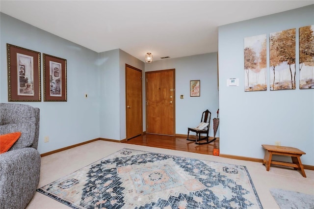 living area with light colored carpet and baseboards