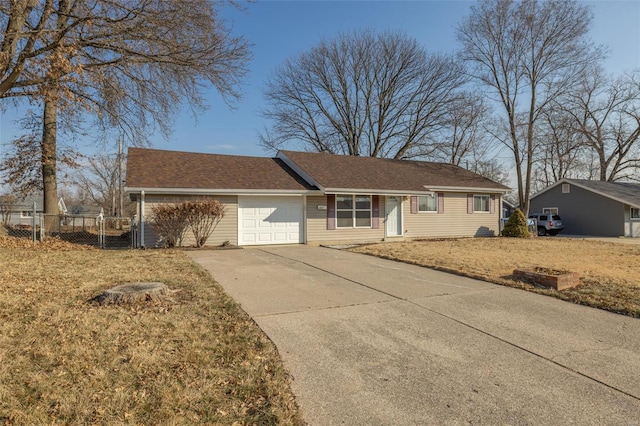 ranch-style home with a garage, driveway, and fence